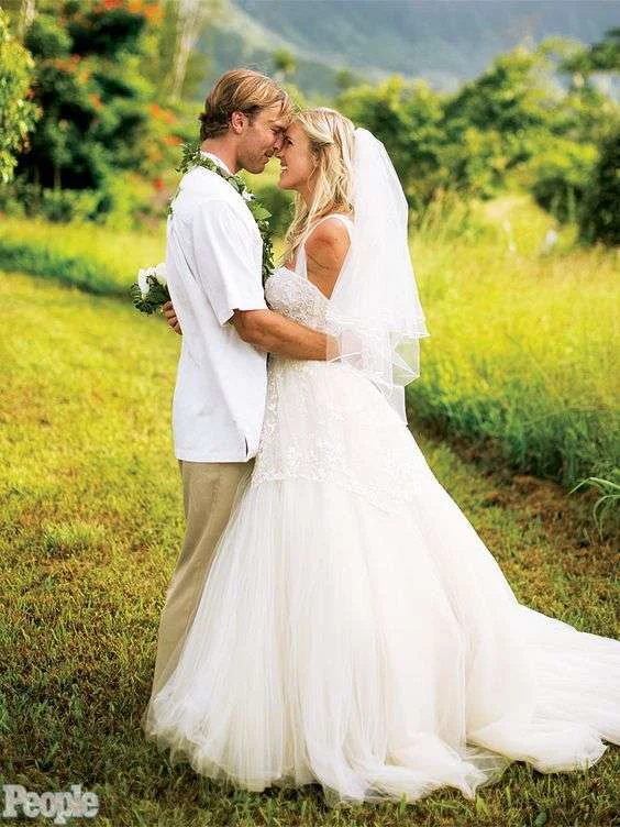 Bethany Hamilton and her husband on their wedding day in Kauai, bride in a strapless Mon Amie gown